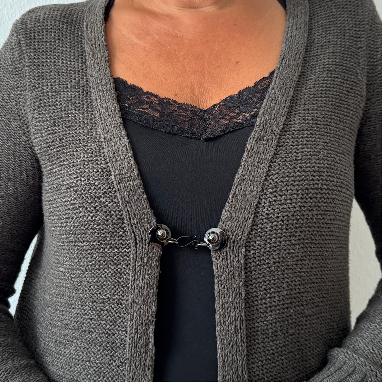 Glanzend zwarte vestsluiting De Classic met haak en oog, compact en stijlvol toegepast in een open vest.