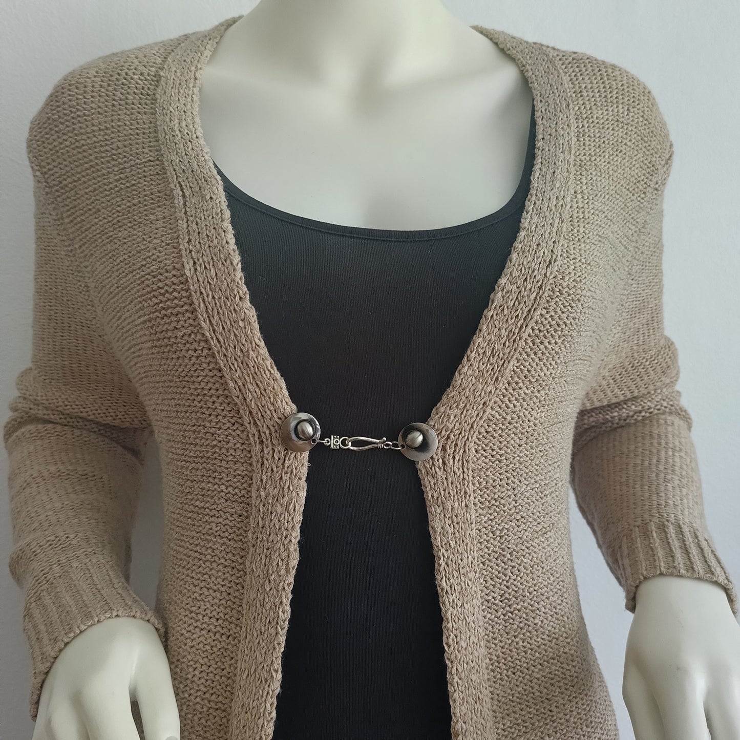 Zilverkleurige vestsluiting De Classic met haak-en-oogsluiting, gedragen op een open gebreid vest.