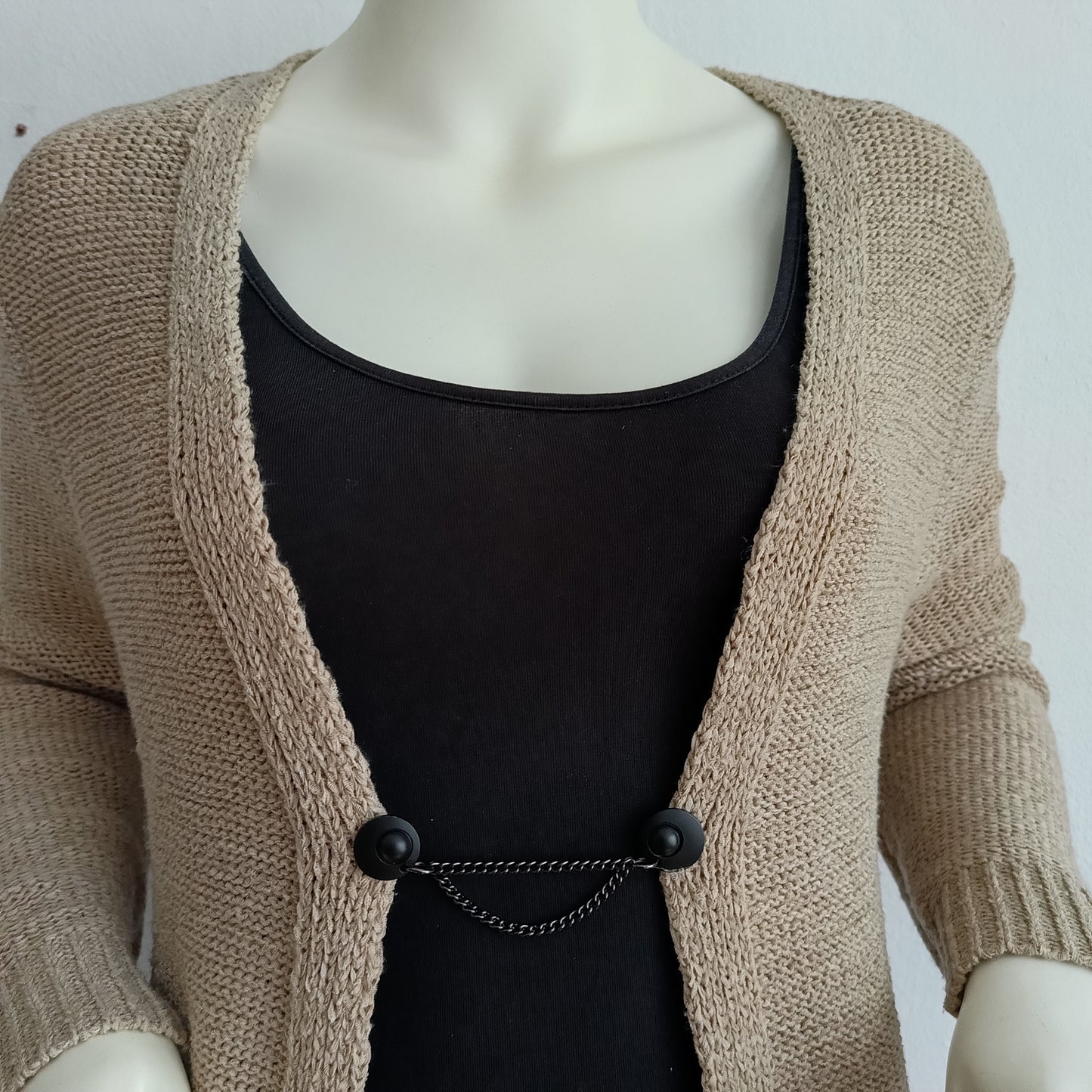 Mat zwarte vestsluiting met twee subtiele kettingen, handgemaakt voor een moderne en elegante afwerking.