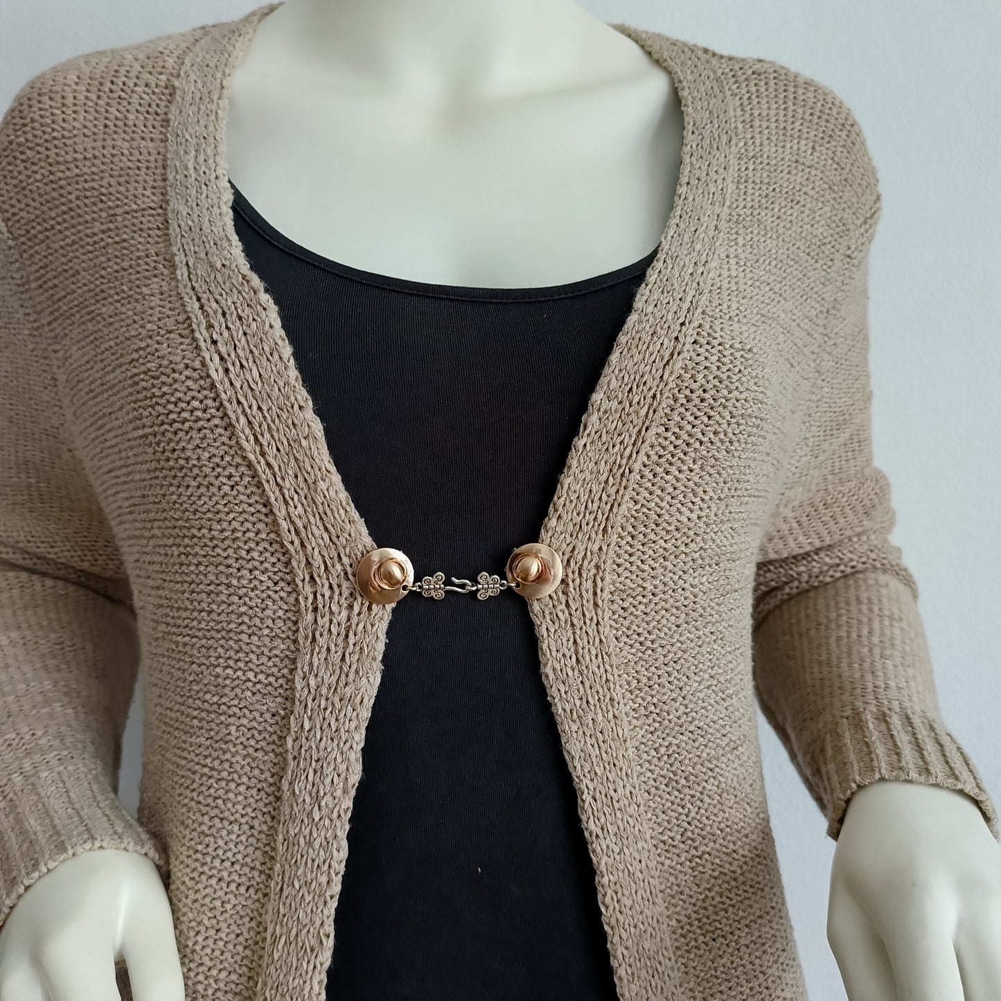 Goudkleurige haak-en-oog vestsluiting met sierlijke vlinderdetails, handgemaakt voor een elegante en subtiele afwerking.