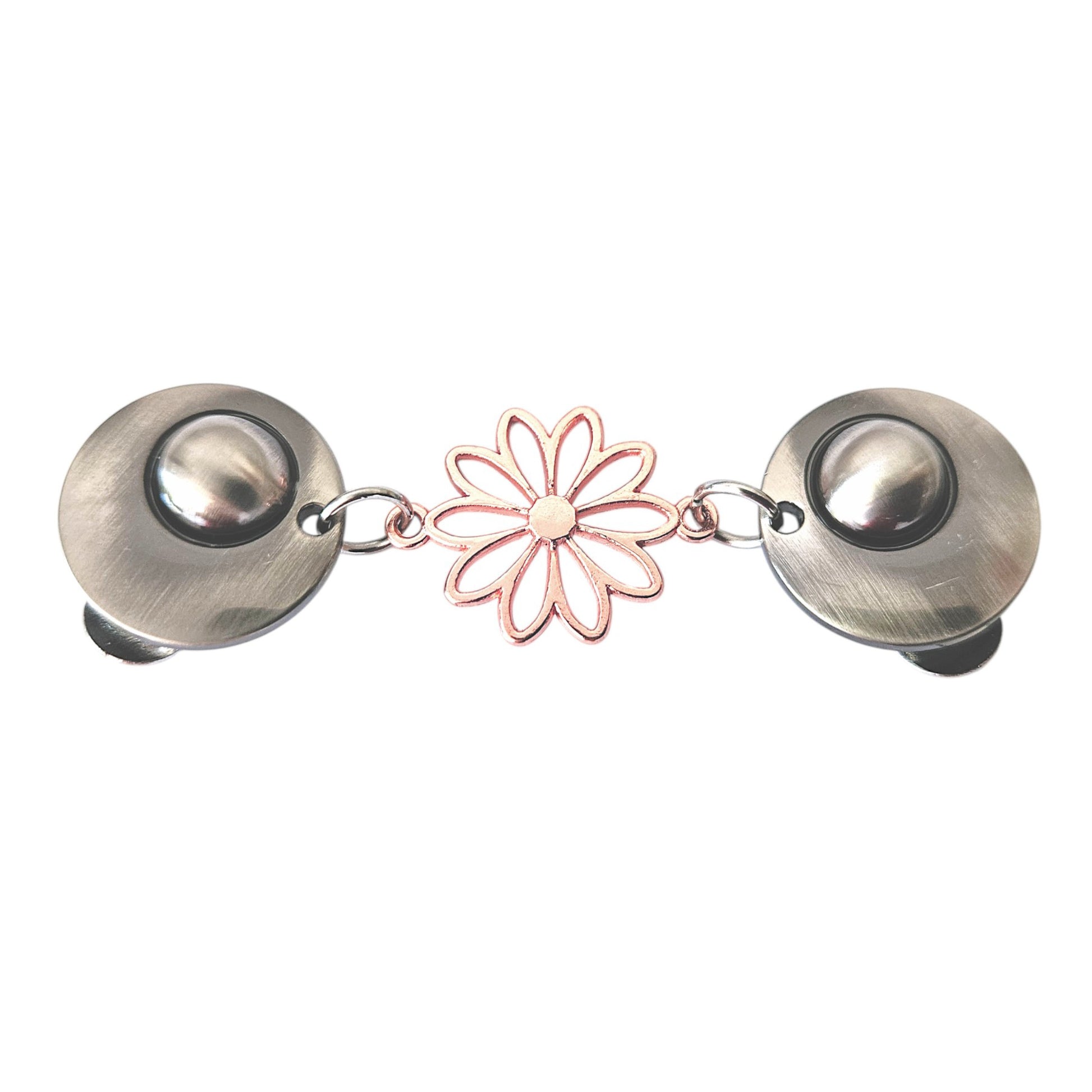 Vrolijke vestsluiting met zilverkleurige clips en een roségouden opengewerkte margriet, symbool voor frisheid en elegantie.