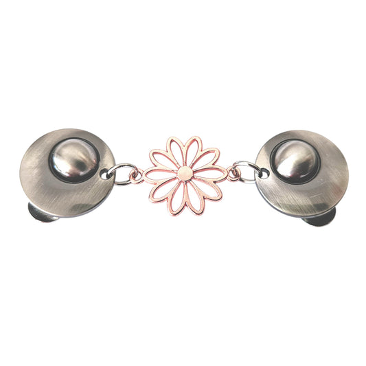 Vrolijke vestsluiting met zilverkleurige clips en een roségouden opengewerkte margriet, symbool voor frisheid en elegantie.