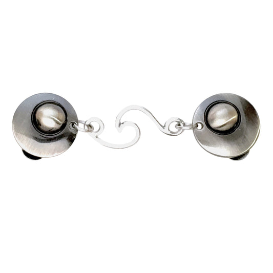 Minimalistische zilverkleurige vestsluiting met elegante golvende schakel, voor een subtiele en stijlvolle look.