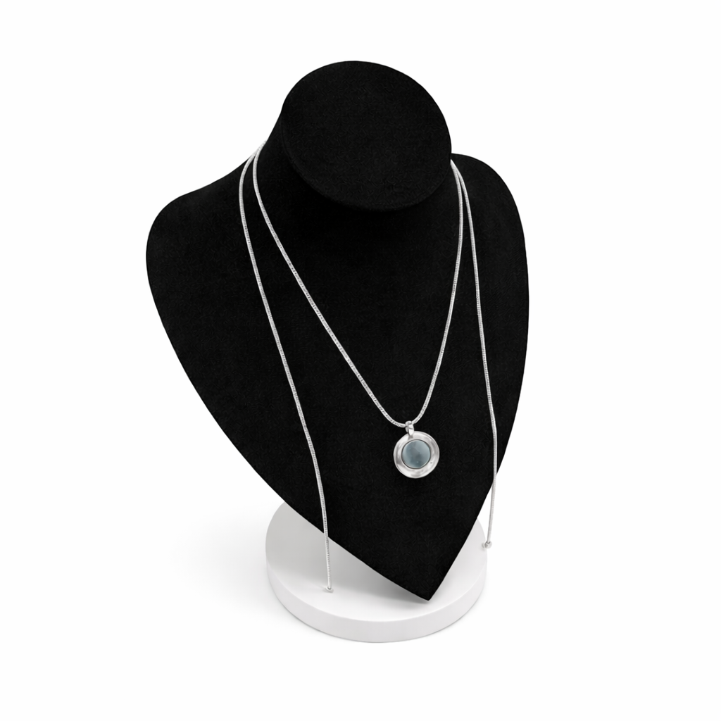 Zilverkleurige magneetketting getoond op zwart display, met ronde broche als voorbeeld bevestigd