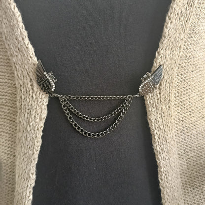 Zwartkleurige vestsluiting met sierlijke vleugels en drie fijne kettingen, handgemaakt voor een krachtige en elegante uitstraling.