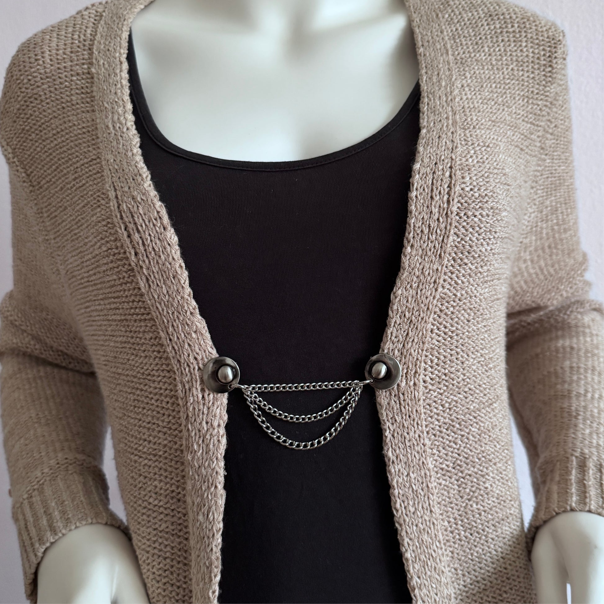 Vestsluiting De Keten in zilverkleur met drie fijne kettingen, zorgt voor een elegante en speelse sluiting van een vest.