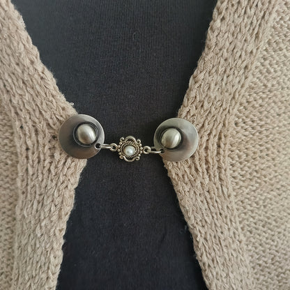 Elegante vestsluiting met zilverkleurige parelbedel, handgemaakt in Groningen voor subtiele stijlvolle verfijning.