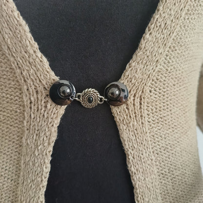 Handgemaakte vestsluiting De Steen in zwart met zilverkleurig detail, stijlvolle clip voor vest of sjaal.