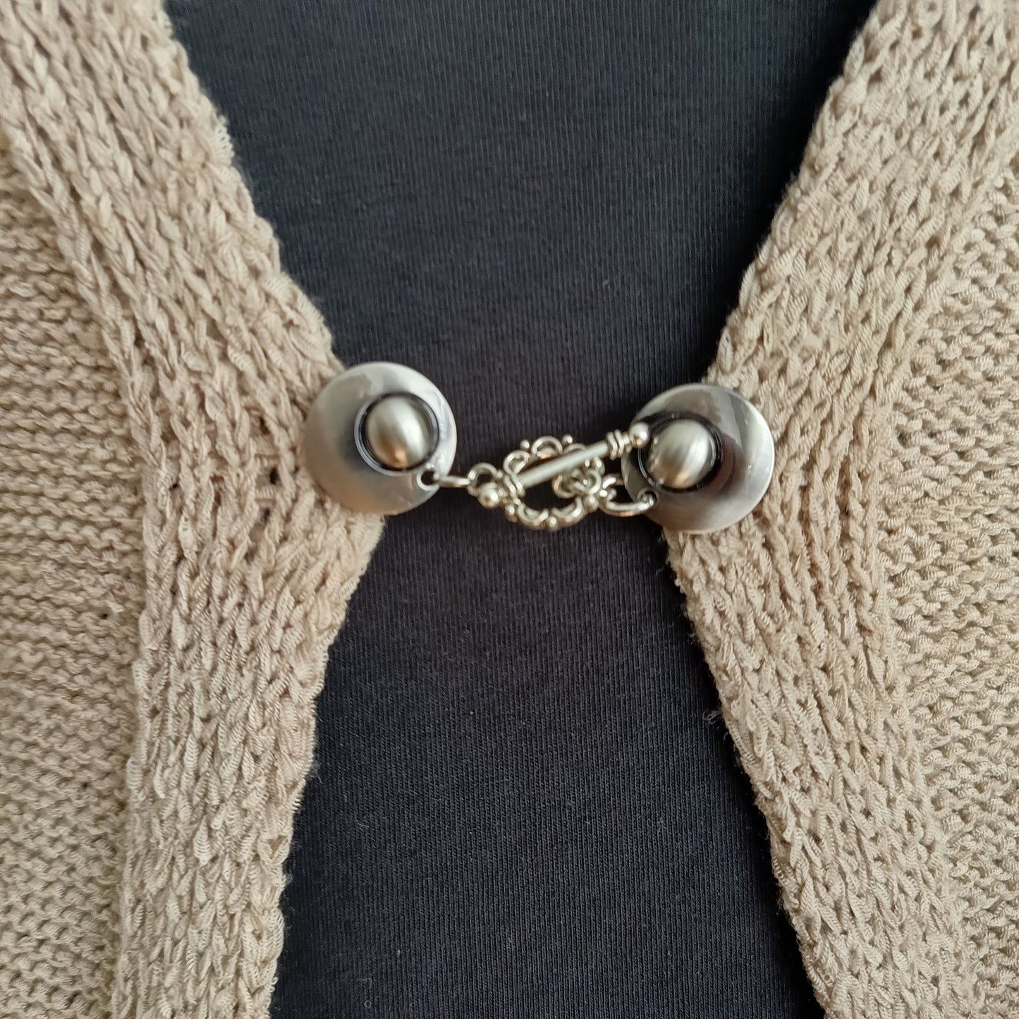 Zilverkleurige vestsluiting met een sierlijke bloemrand-bedel, handgemaakt voor een elegante en verfijnde uitstraling.