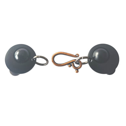 vestsluiting met mat zwarte clips en een koperkleurige haak-en-oog sluiting, handgemaakt voor een stijlvolle en warme uitstraling.