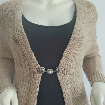 Zilverkleurige vestsluiting met een grote parelbedel, handgemaakt voor een elegante en tijdloze afwerking.
