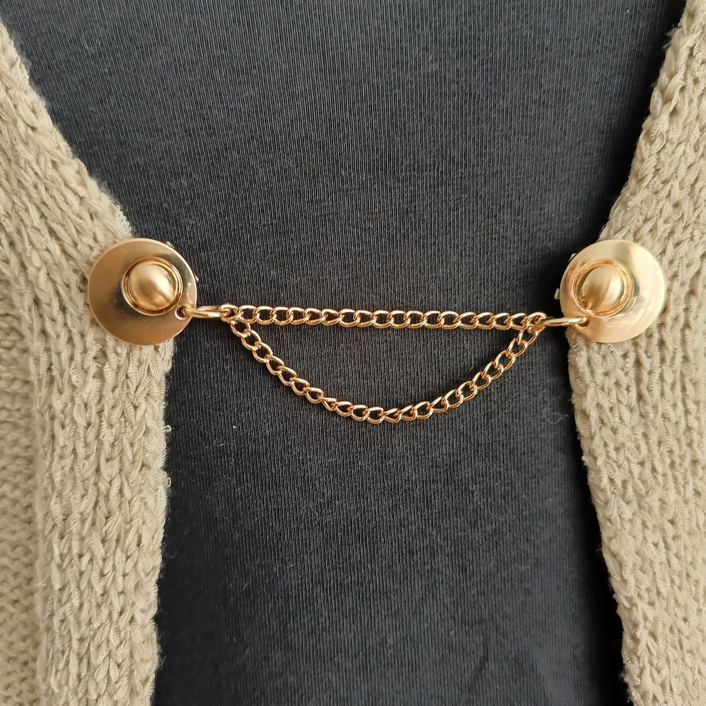 Goudkleurige vestsluiting met twee verfijnde kettingen, handgemaakt voor een stijlvolle en chique uitstraling.