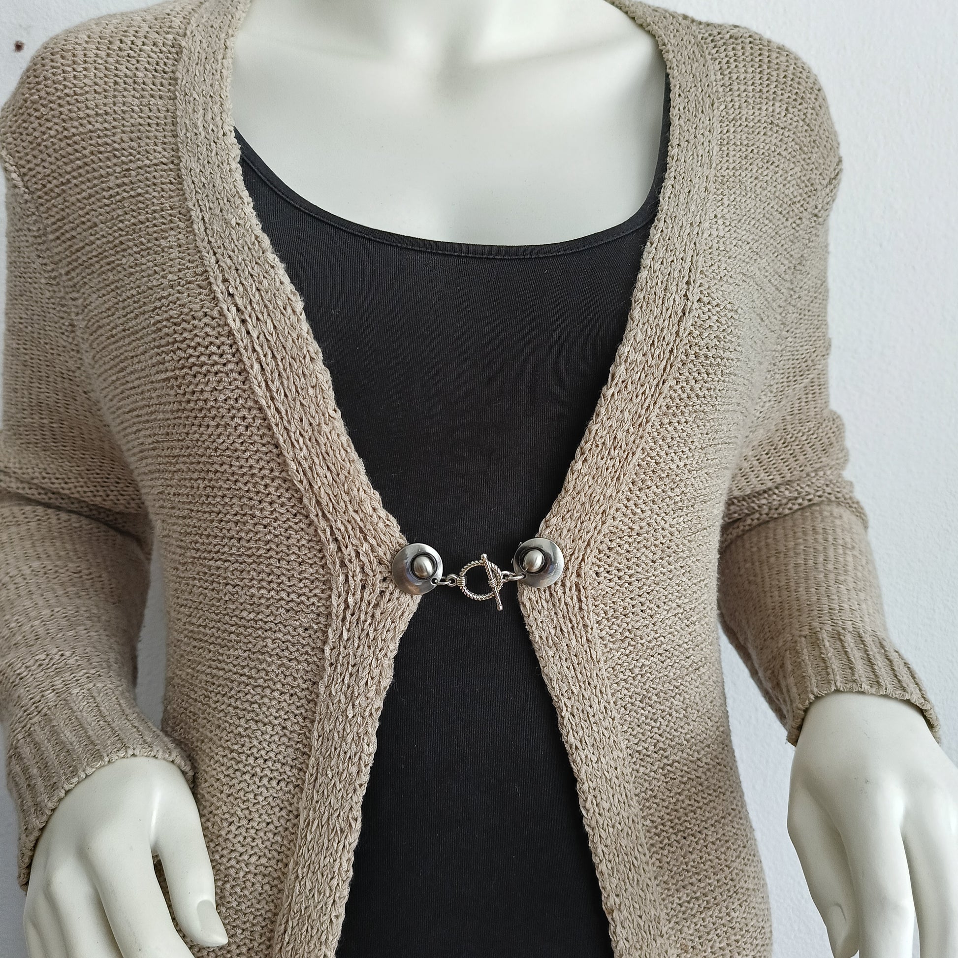 Zilverkleurige vestsluiting met een verfijnde spiraalvormige bedel, handgemaakt voor een elegante en tijdloze afwerking.