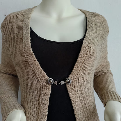 Zilverkleurige haak-en-oog vestsluiting met elegante vlinderdetails, handgemaakt voor een subtiele en stijlvolle afwerking.