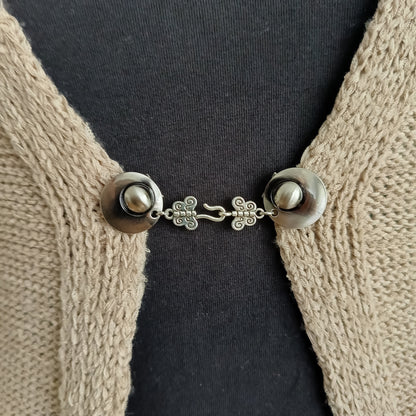 Zilverkleurige haak-en-oog vestsluiting met sierlijke vlinderdetails, handgemaakt voor een elegante en verfijnde uitstraling.