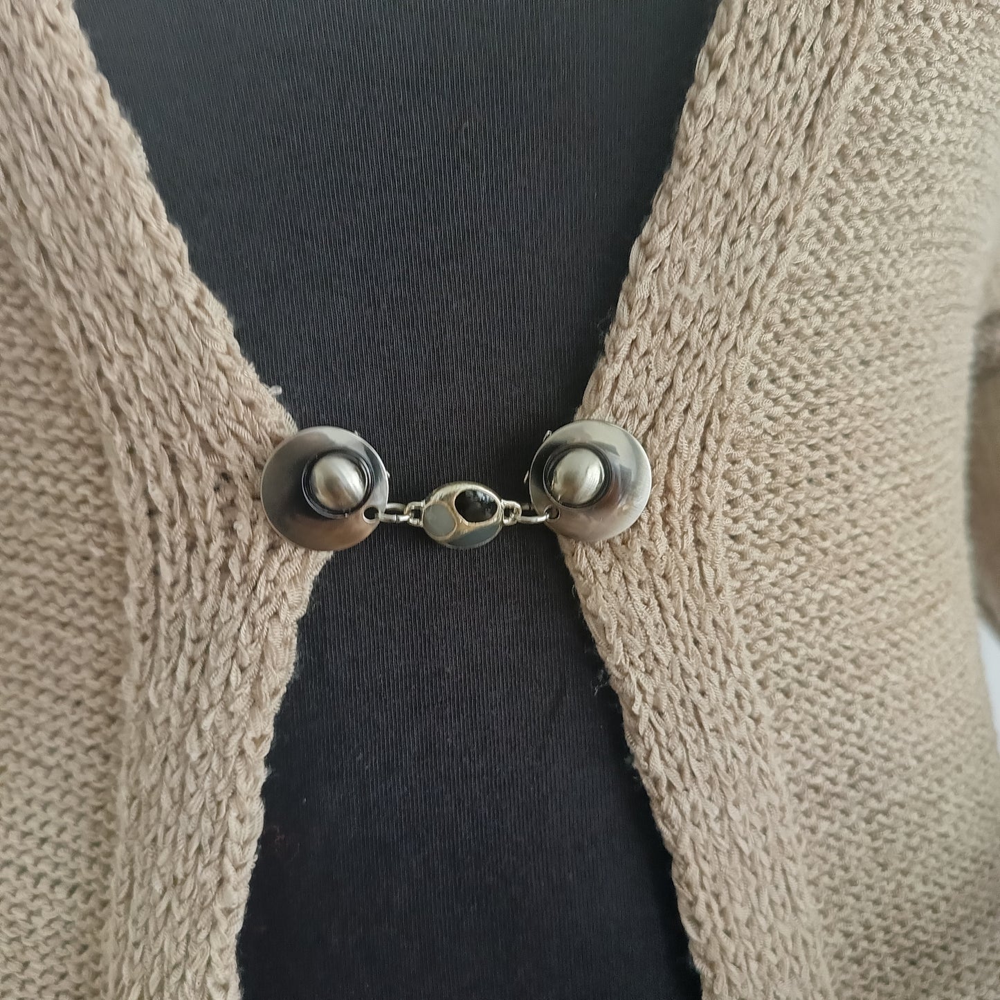 Zilverkleurige vestsluiting met een bedel in drie grijstinten, handgemaakt voor een stijlvolle en subtiele uitstraling.