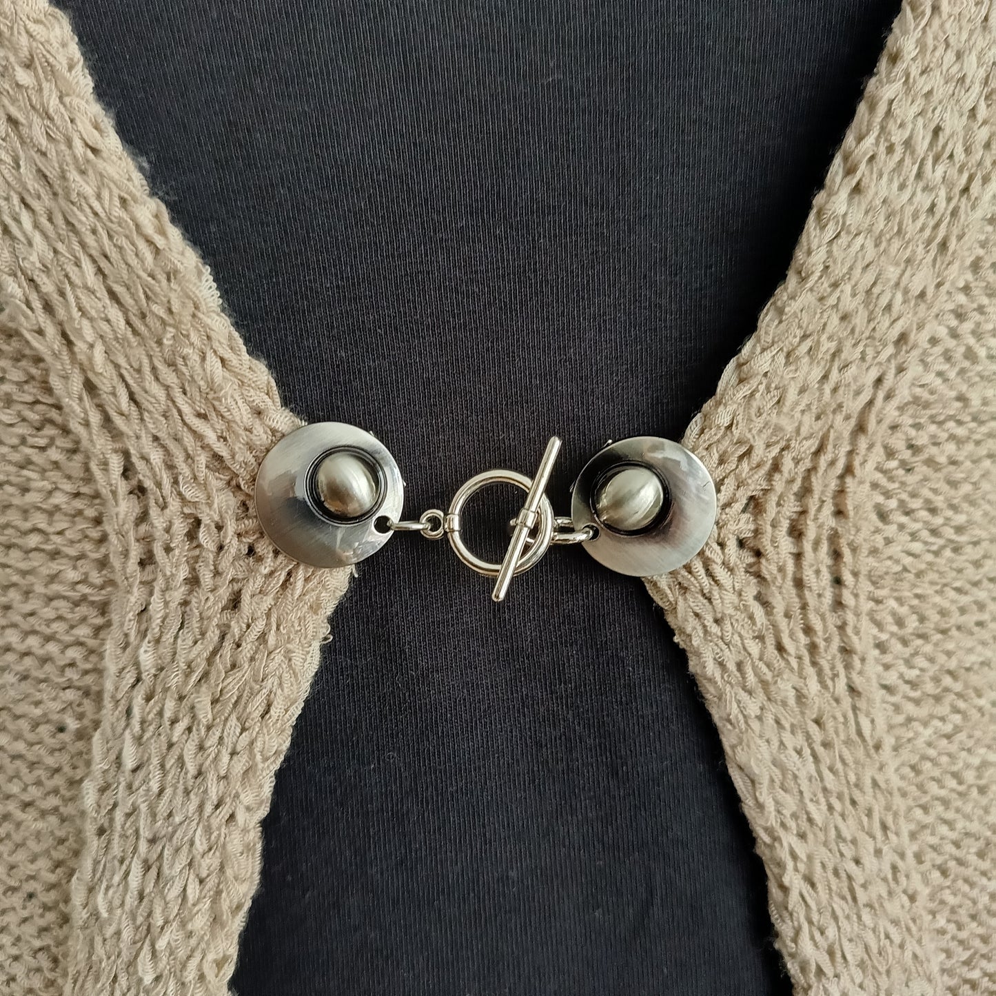 Zilverkleurige T-Bar vestsluiting met een stijlvol houtje-touwtje ontwerp, handgemaakt voor een praktische en elegante bevestiging.