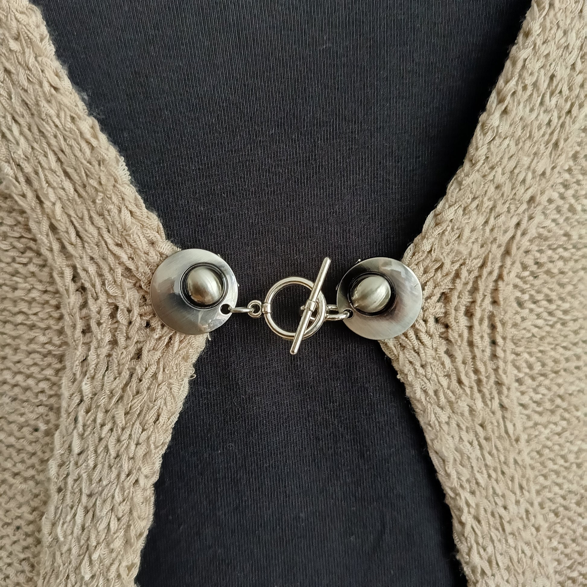 Zilverkleurige T-Bar vestsluiting met een stijlvol houtje-touwtje ontwerp, handgemaakt voor een praktische en elegante bevestiging.