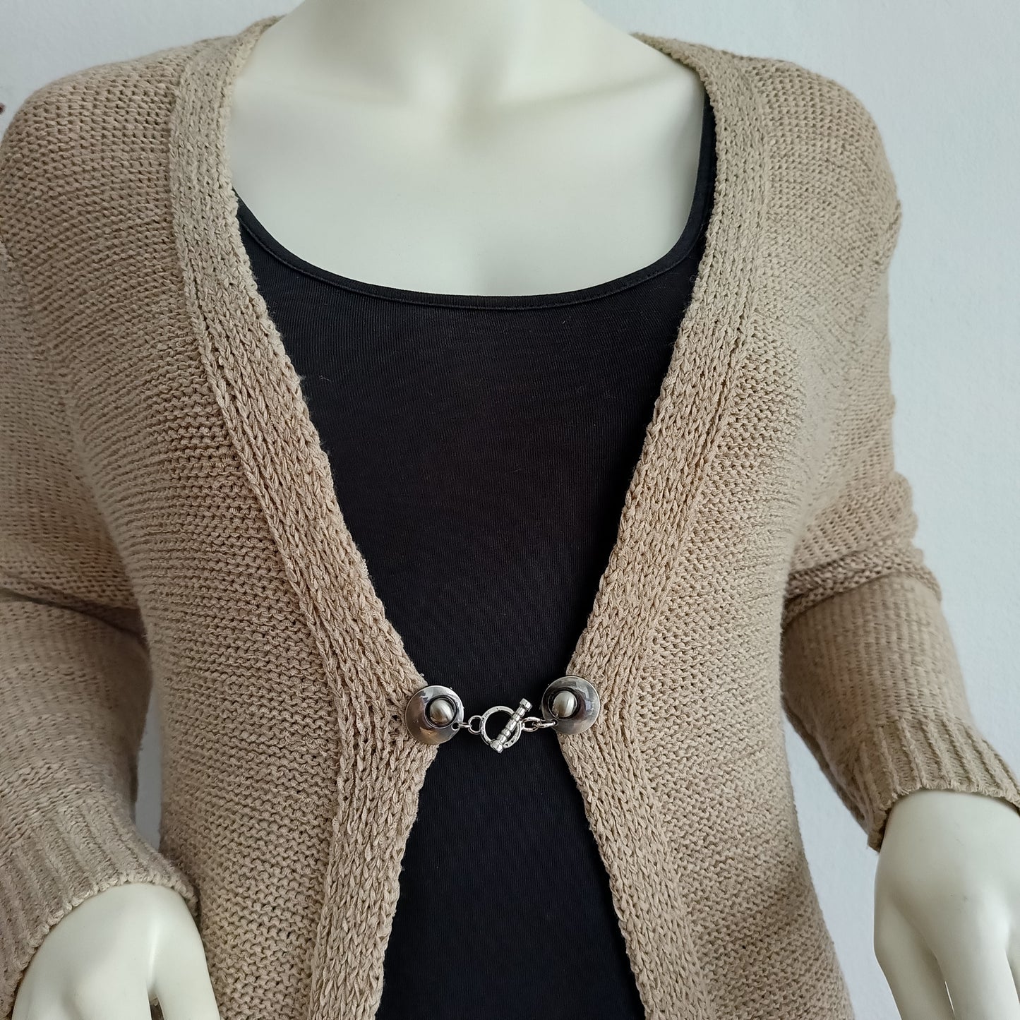 Zilverkleurige vestsluiting met een sierlijke ritme-bedel, handgemaakt voor een elegante en verfijnde afwerking.