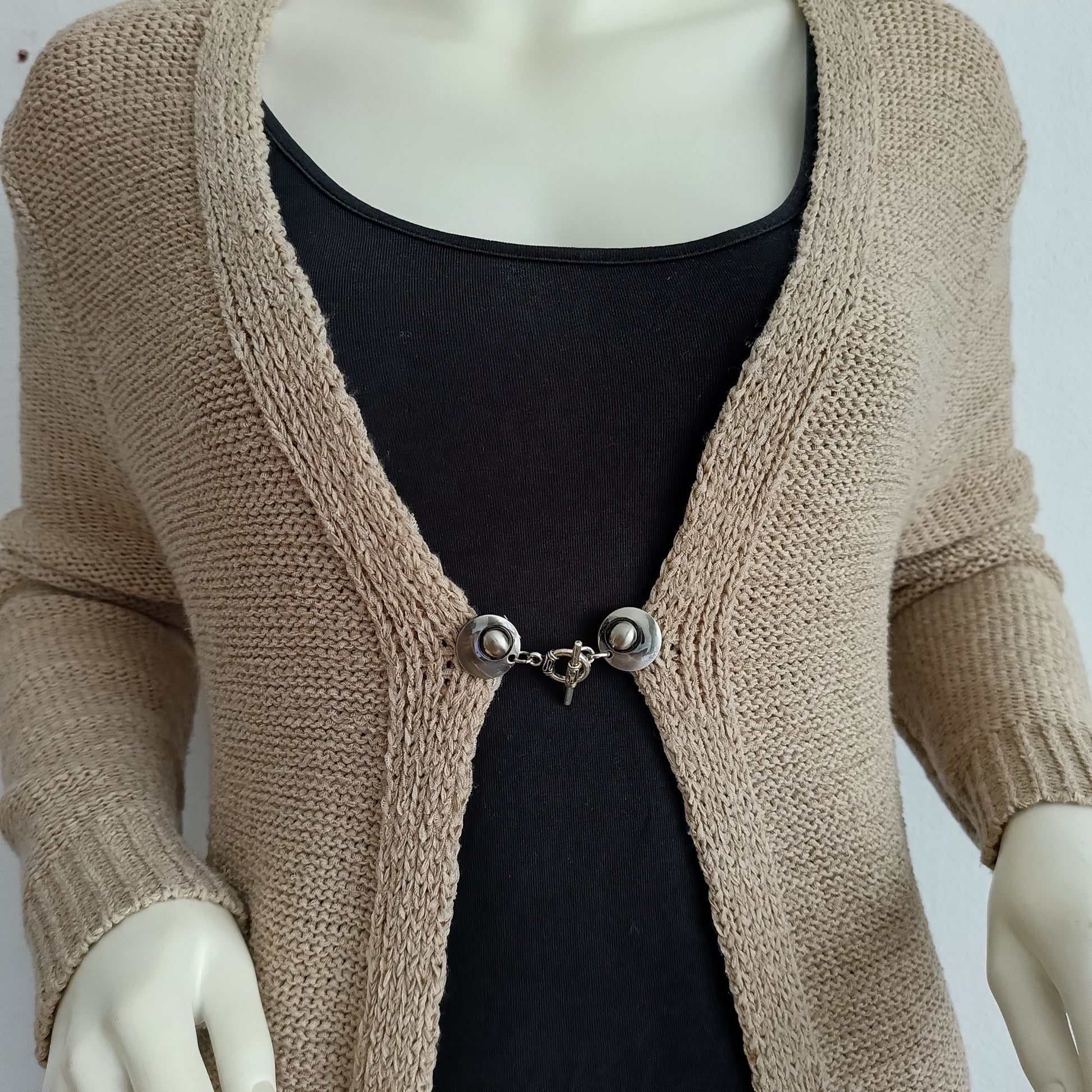 Zilverkleurige vestsluiting met een verfijnde evenwichtsbedel, handgemaakt voor een subtiele en stijlvolle uitstraling.