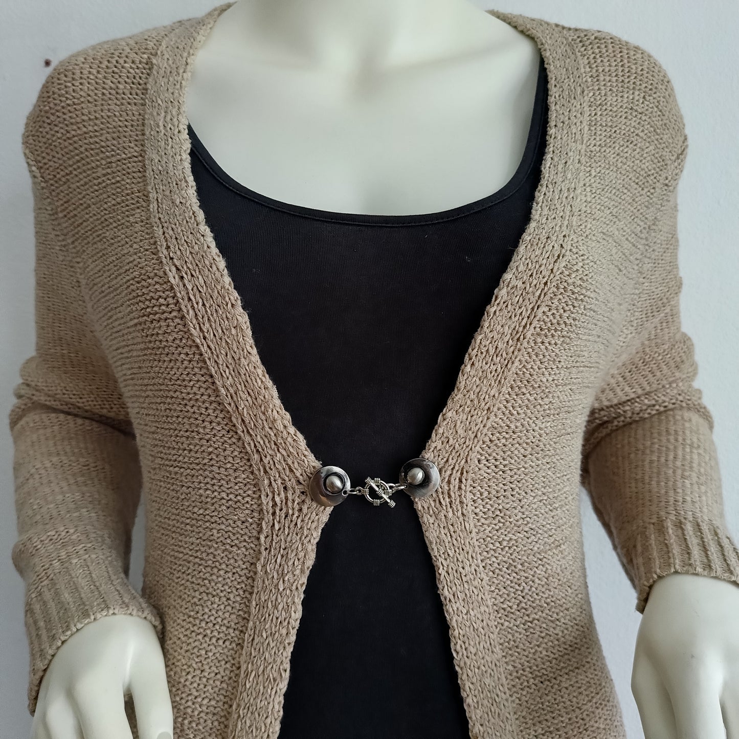 Zilverkleurige vestsluiting met een verfijnde structuurbedel, handgemaakt voor een elegante en tijdloze afwerking.