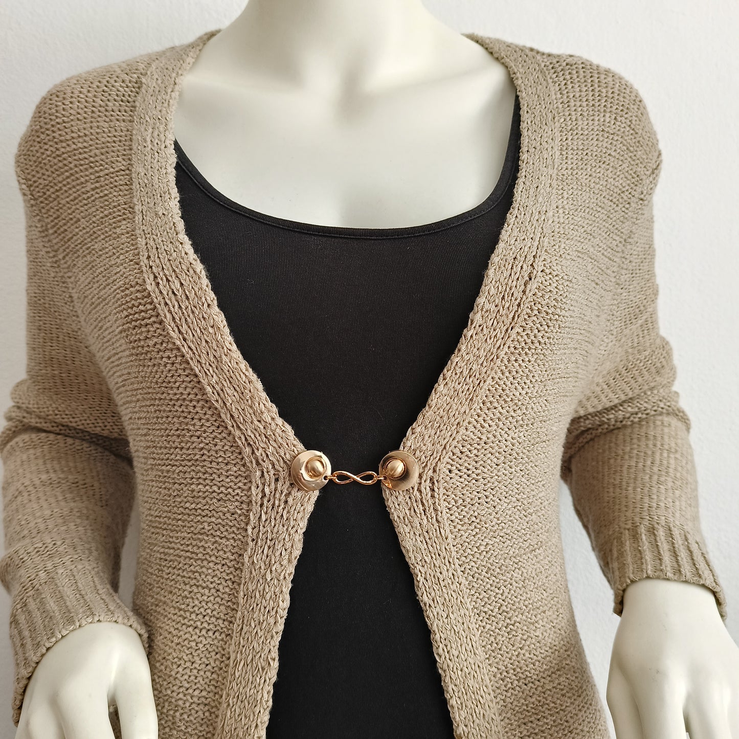 “Handgemaakte vestclip Infinity van Fashionclip in goudkleur met oneindigheidssymbool, subtiele blikvanger die kracht en elegantie uitstraalt.