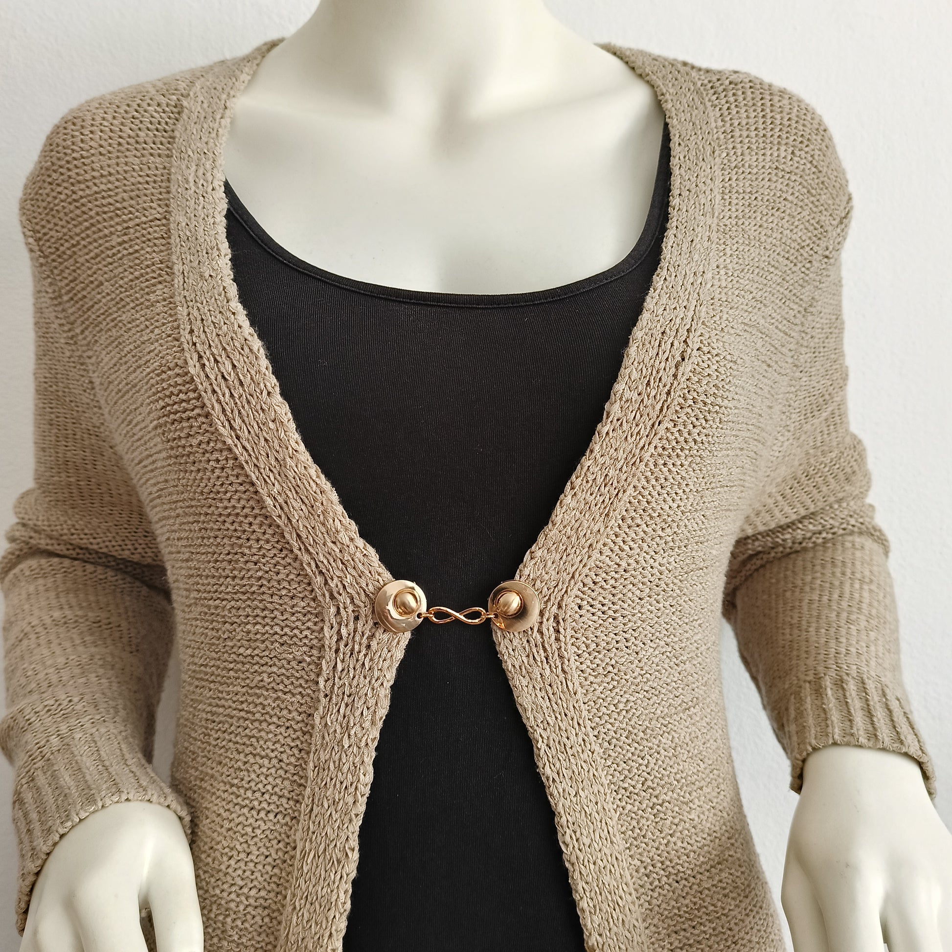 “Handgemaakte vestclip Infinity van Fashionclip in goudkleur met oneindigheidssymbool, subtiele blikvanger die kracht en elegantie uitstraalt.