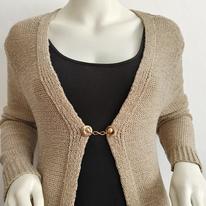 “Handgemaakte vestclip Infinity van Fashionclip in goudkleur met oneindigheidssymbool, subtiele blikvanger die kracht en elegantie uitstraalt.