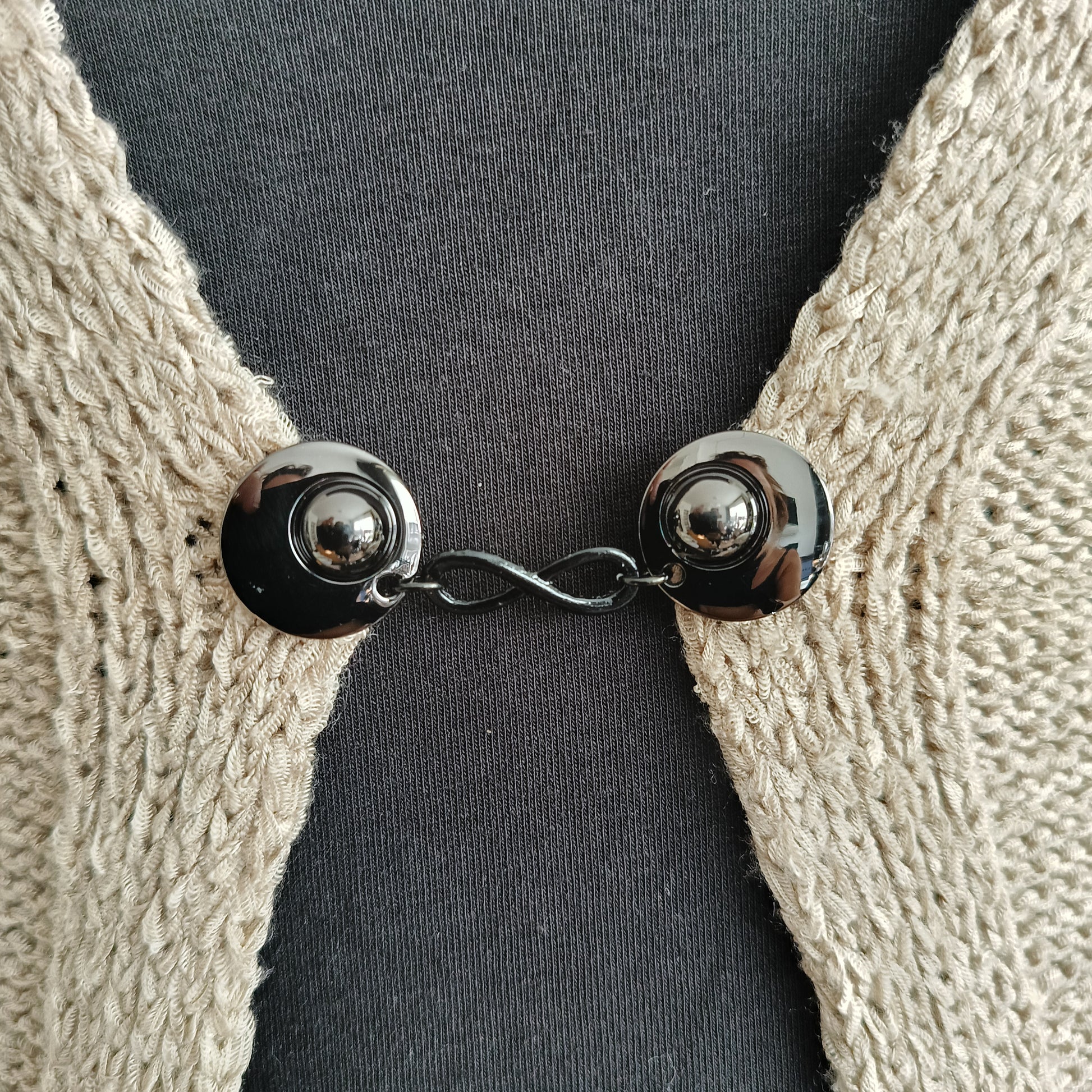 Handgemaakte vestsluiting Infinity van Fashionclip in glanzend zwart met oneindigheidssymbool, stijlvol accessoire dat kracht en verbinding uitstraalt.