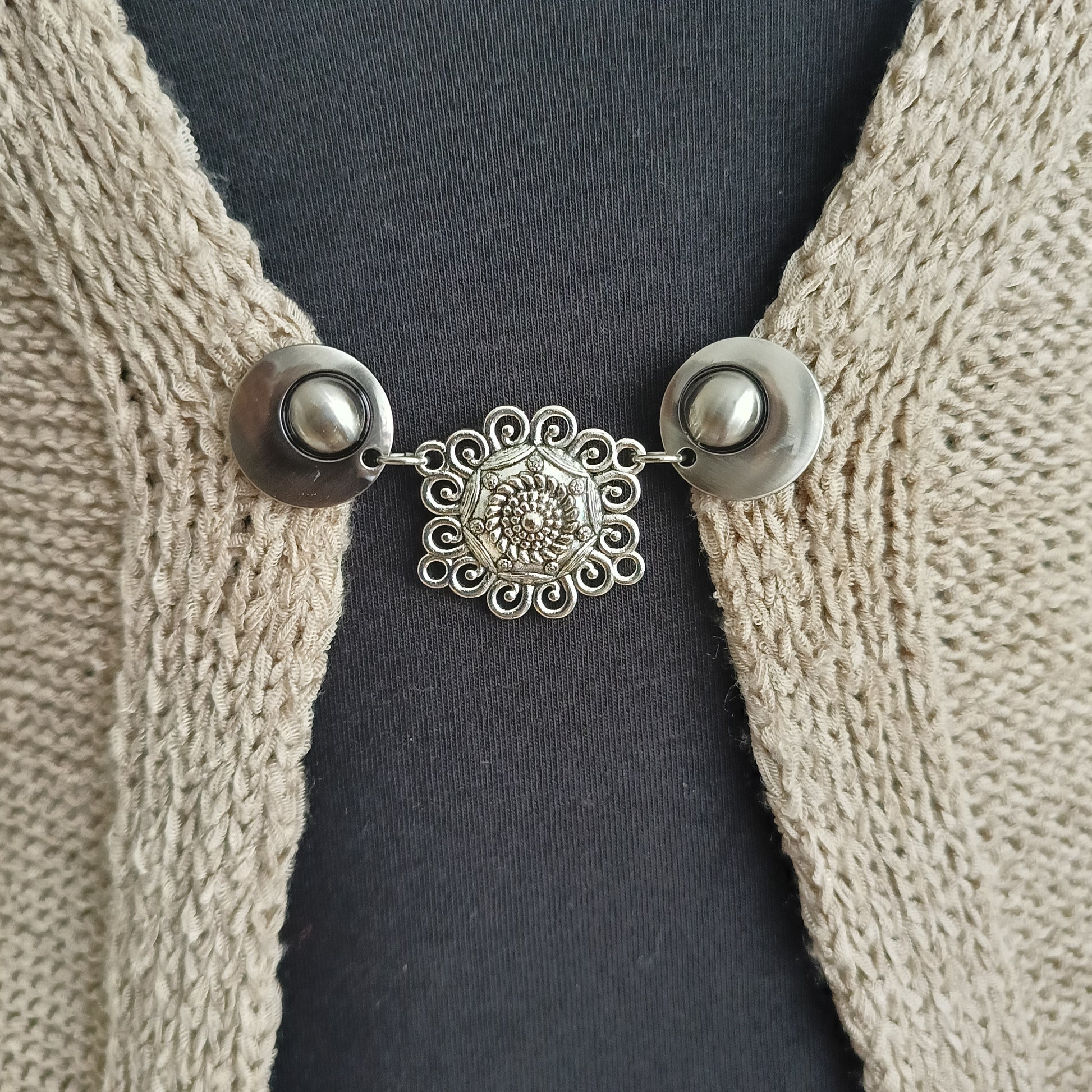 Handgemaakte zilverkleurige vestsluiting Knoopkunst van Fashionclip met verfijnd knoopmotief, een symbool van vakmanschap en tijdloze stijl.