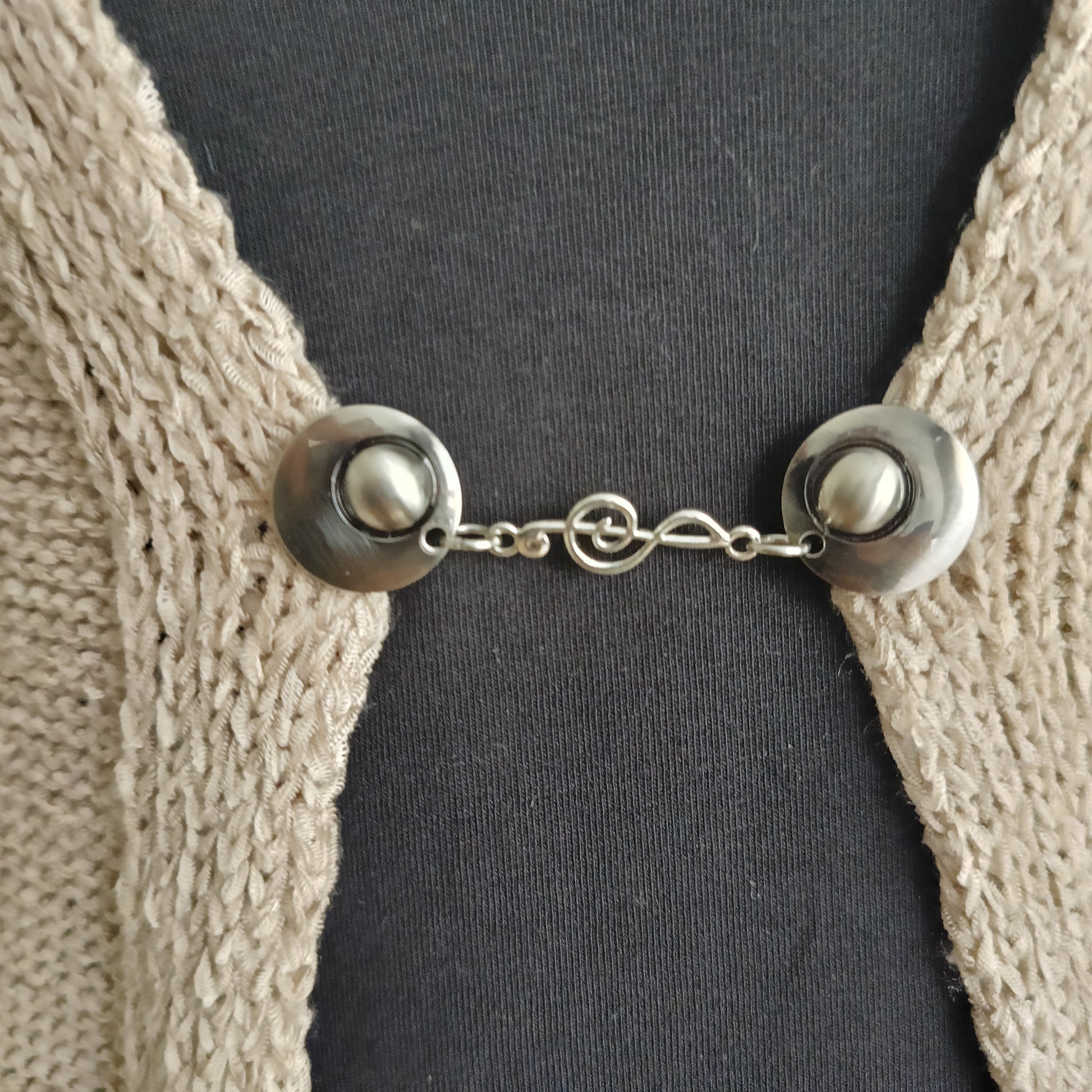 Detail van handgemaakte vestsluiting De Muzieknoot van Fashionclip in zilverkleurig metaal, met sierlijke muzieknootvorm als elegant middenstuk