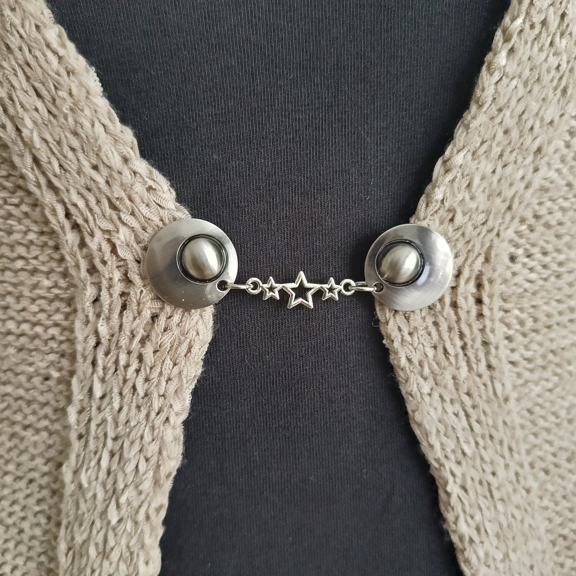 Handgemaakte zilverkleurige vestsluiting Sterretjes van Fashionclip met verfijnd sterrenmotief, symbool voor licht, verbinding en elegantie.