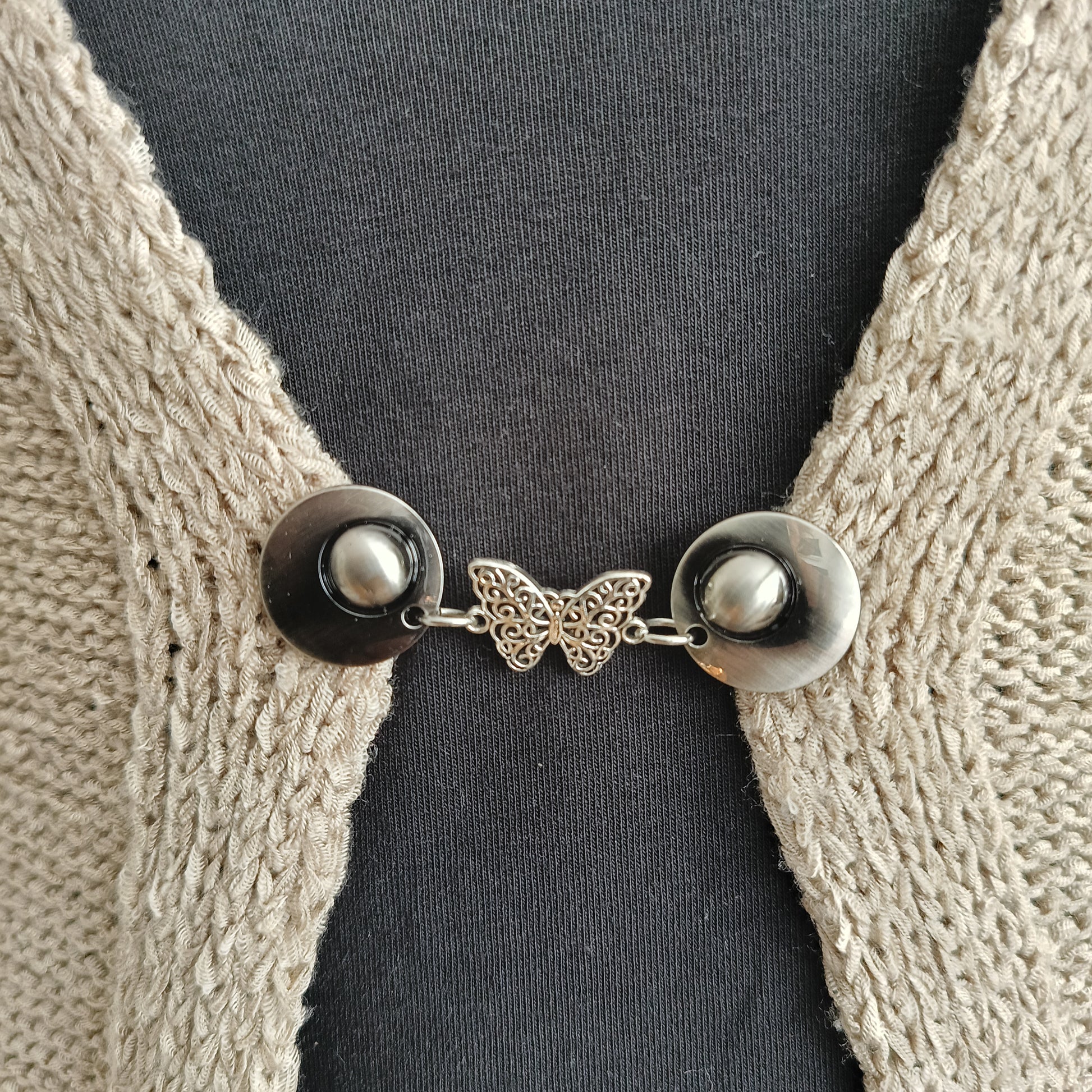Handgemaakte zilverkleurige vestsluiting De Vlinder van Fashionclip met fijn opengewerkt vlindermotief, symbool voor vrijheid en lichtheid.