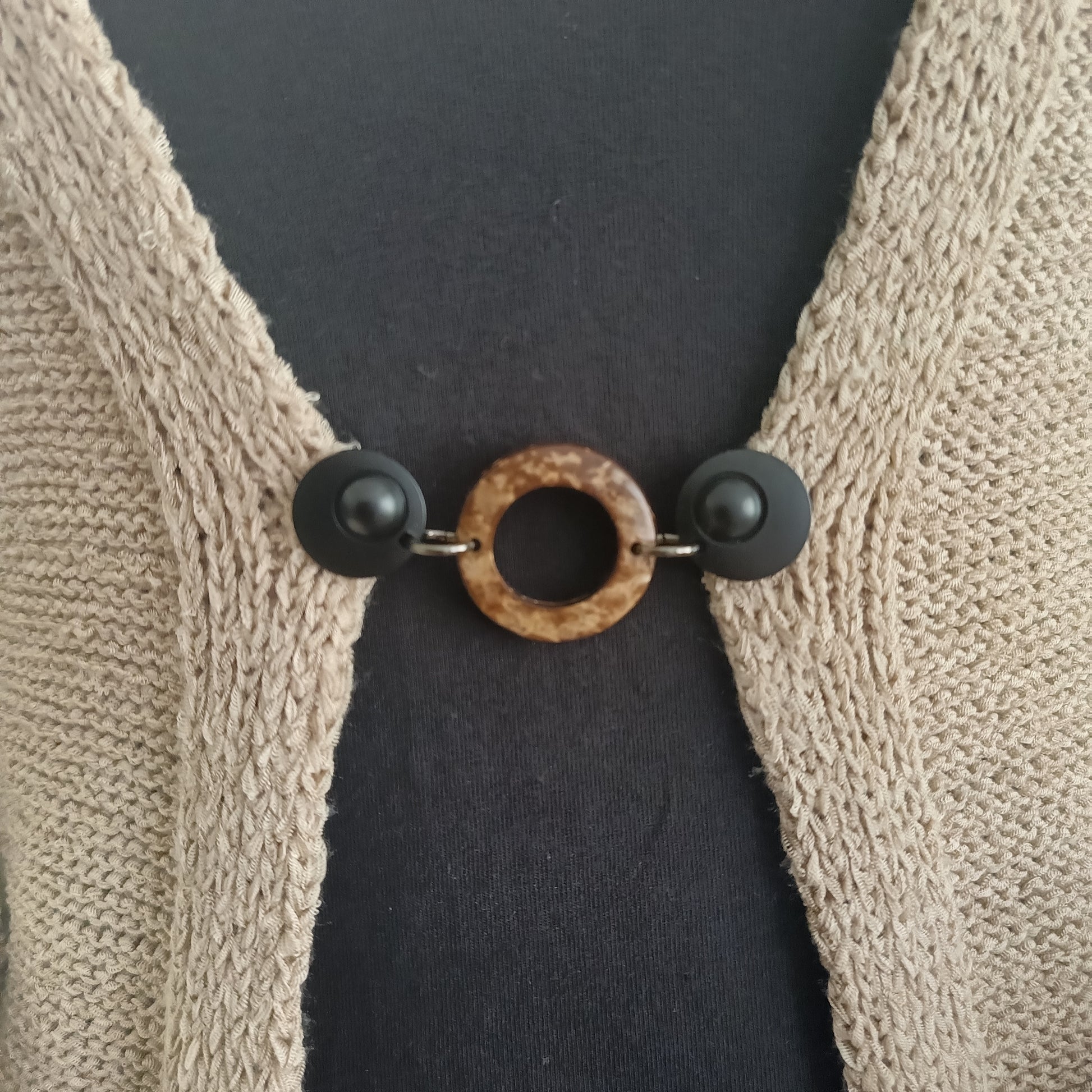 Handgemaakte vestsluiting Kokosnoot in mat zwart, met een natuurlijke, ronde vorm en een rustige, stijlvolle uitstraling.