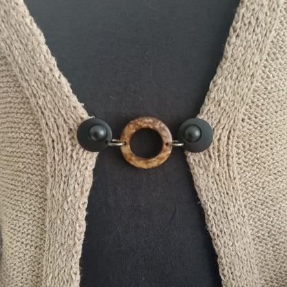 Handgemaakte vestsluiting Kokosnoot in mat zwart, met een natuurlijke, ronde vorm en een rustige, stijlvolle uitstraling.