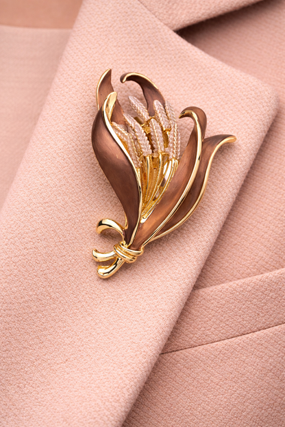 Magneetbroche Nr.08 Gouden Oogst gedragen op een zachtroze colbert, elegante damesbroche met bloemvorm in warme goud- en bruintinten.