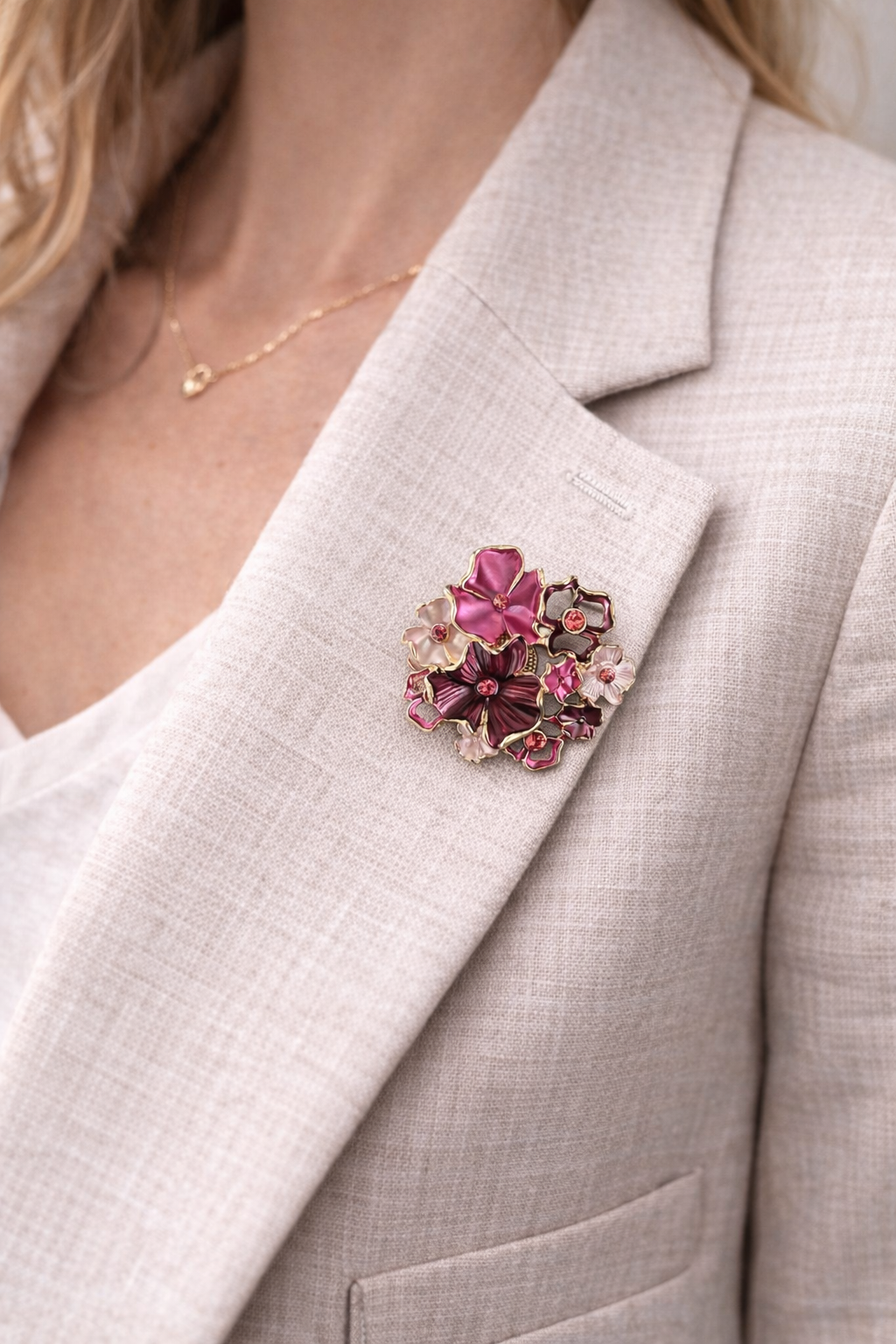 Magneetbroche Nr.18 Bloemenpracht gedragen op een licht colbert, elegante damesbroche met roze en paarse bloemen en sprankelende details.