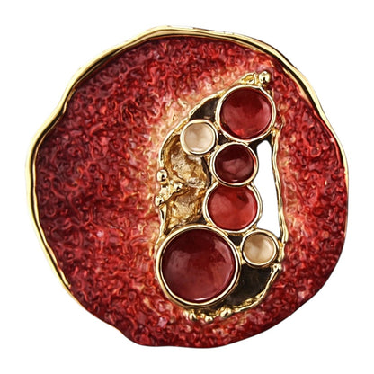 Rode magneetbroche Robijn Pracht met goudkleurige details, diepe robijnrode accenten en een opvallend rond ontwerp. Een elegante broche zonder speld die iedere outfit een luxe uitstraling geeft.