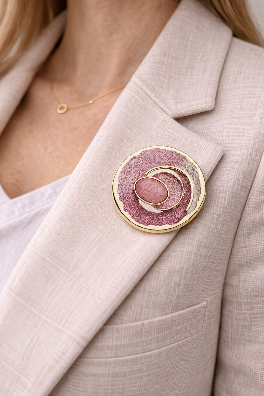 Magneetbroche Nr.21 Roze Goudcirkel gedragen op een licht colbert, elegante damesbroche met roze tinten en goudkleurige cirkelvormen.
