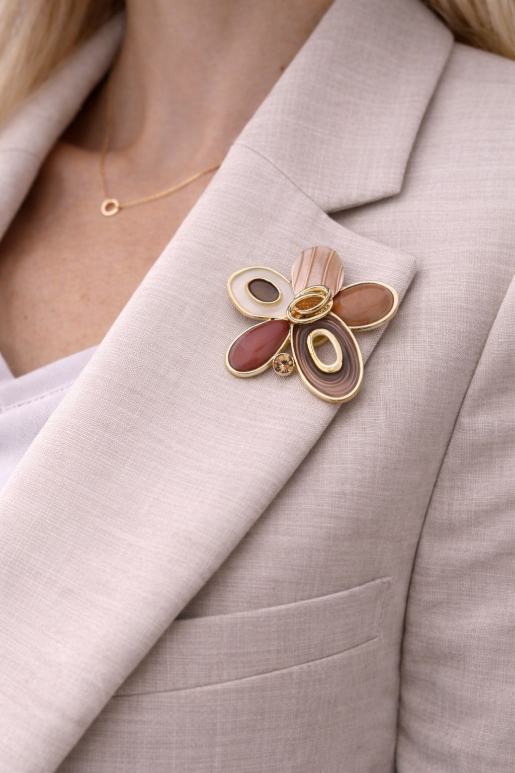 Magneetbroche Nr.22 Bloem bruintinten gedragen op een licht colbert, elegante damesbroche met warme bruintinten en goudkleurige accenten.