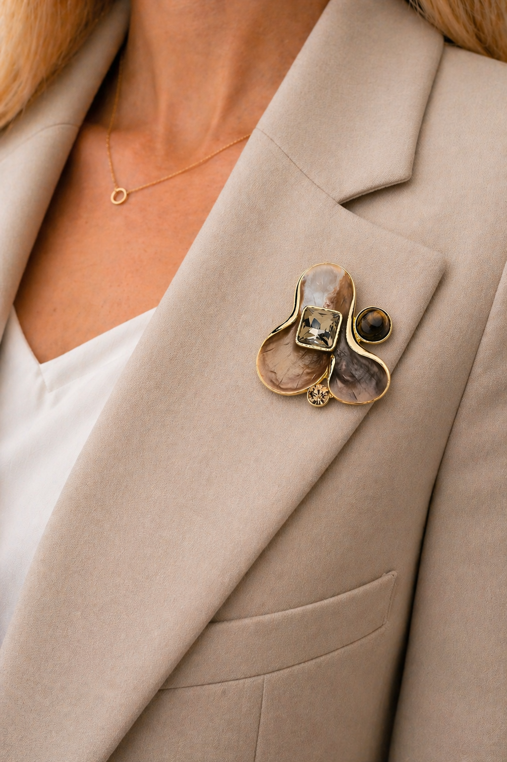 Magneetbroche Nr.26 Gouden Elegantie gedragen op een licht colbert, stijlvolle damesbroche in goud en warme bruintinten.