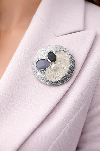 Magneetbroche Nr.31 Zachte Harmonie gedragen op een licht colbert, elegante damesbroche met zachte grijs-, parel- en crèmetinten.