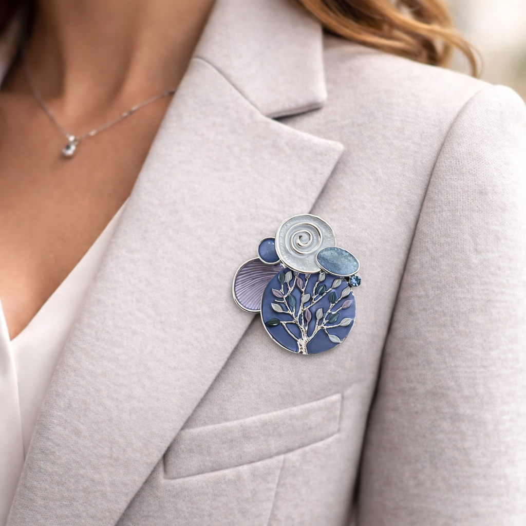 Magneetbroche Nr.41 Blauwe Kracht Levensboom gedragen op een licht colbert, elegante damesbroche met levensboommotief in blauwe tinten.