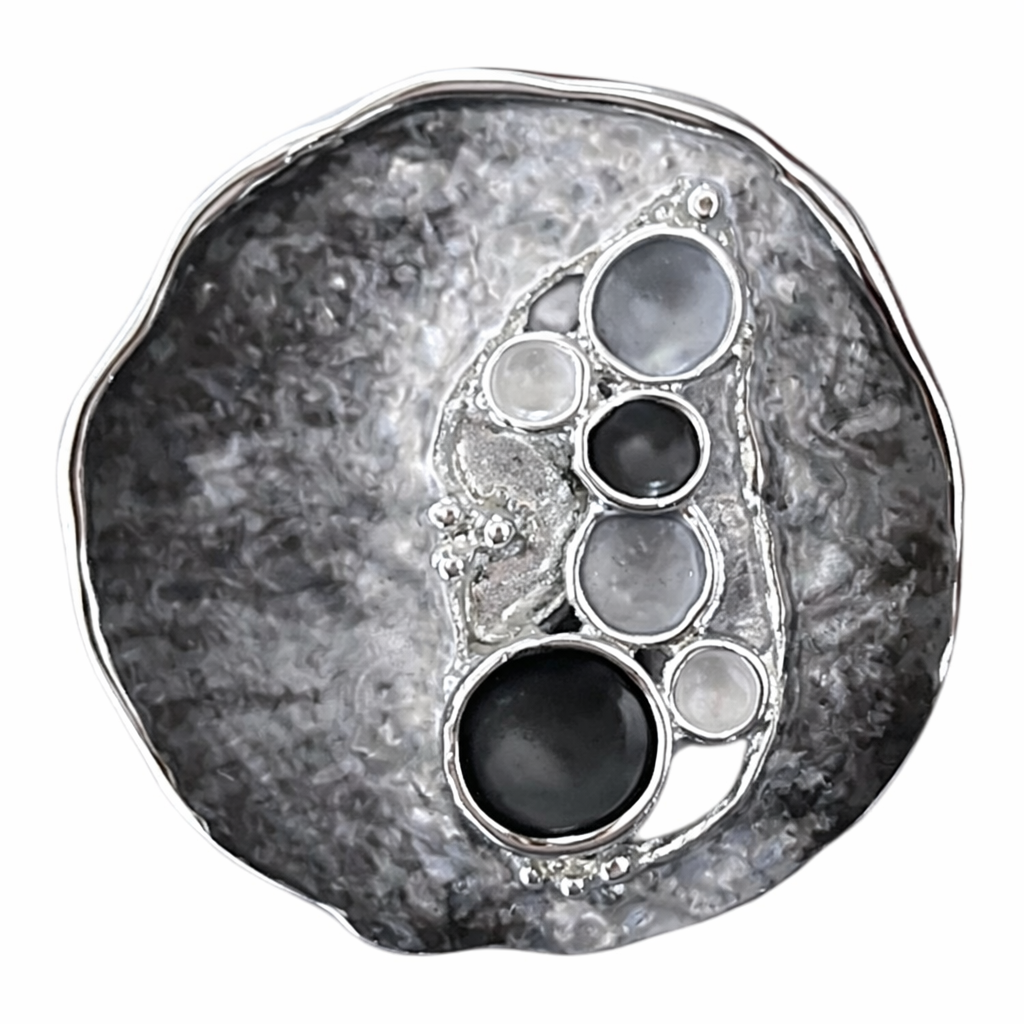 Magneetbroche Nr.42 Zwarte pracht met zwart- en grijstinten, ronde vormen en verfijnde zilverkleurige details.