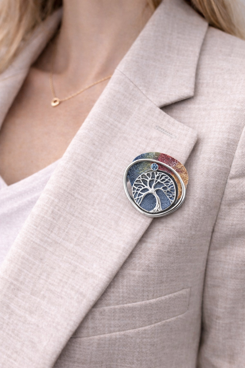 Magneetbroche Nr.44 Kleurrijke levensboom gedragen op een licht colbert, elegante damesbroche met levensboommotief en subtiele multicolor tinten.
