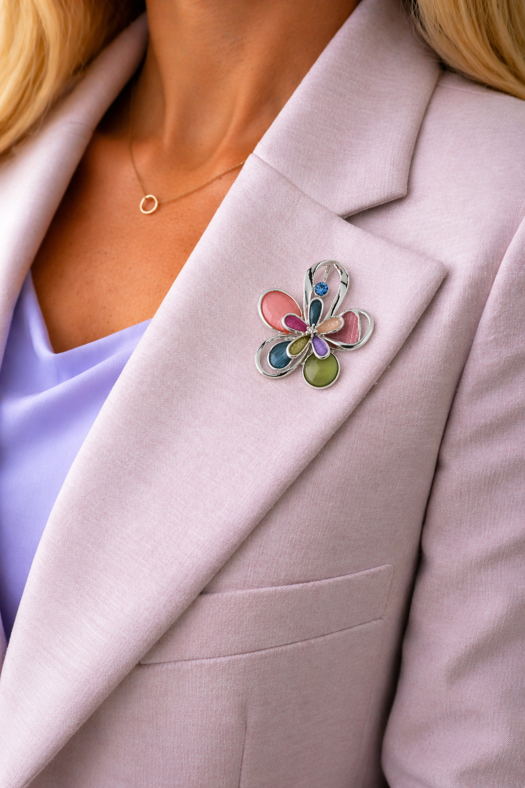 Magneetbroche Nr.59 Kleurrijke bloem zilverkleurig gedragen op een lila colbert, elegante damesbroche met zachte pastelkleuren.