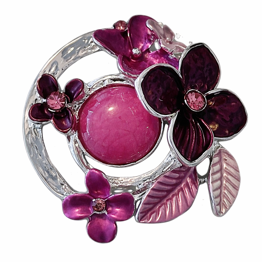 Magneetbroche paars/roze Bloemenkring met bloemen in diepe paarse en roze tinten, ronde vorm en glanzende zilverkleurige details.