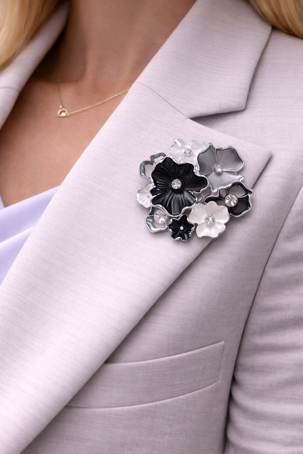 Magneetbroche Tijdloze Bloemenmix gedragen op een licht colbert, bloemen in zwart, wit en zilver met elegante uitstraling.