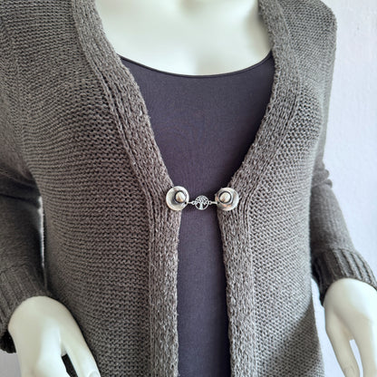 Vestsluiting De Kleine Levensboom gedragen op een taupekleurig gebreid vest, elegante Fashionclip met zilverkleurige clips en levensboom tussenbedel.