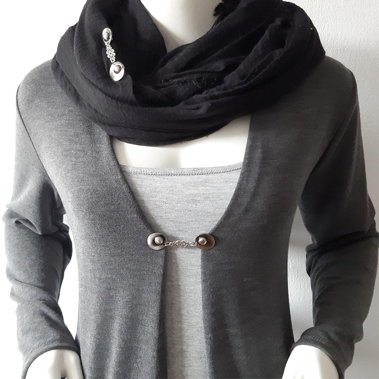 Vestsluiting Griekse Godin gedragen op een grijs vest met zwarte sjaal, elegante Fashionclip met zilverkleurige clips en sierlijke filigraan tussenbedel.